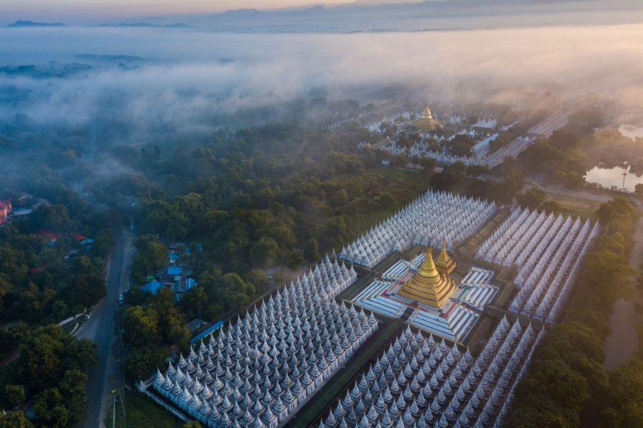 Aerial view of Kuthodaw Pagoda in Mandalay with rows of small white shrines in morning mist
